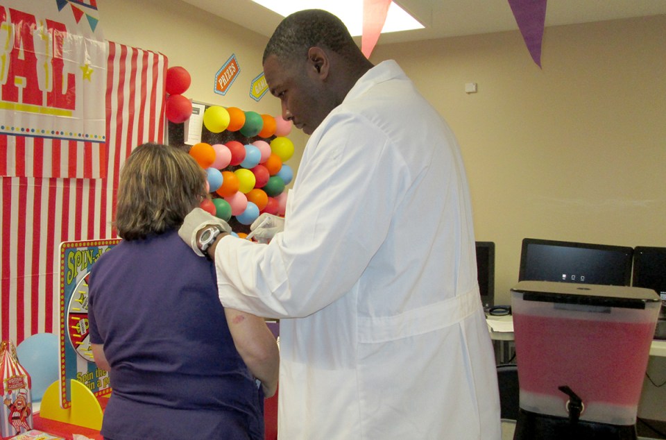 Associate Chief Nursing Officer Dexter Hodge administers the flu shot at a hospital event.