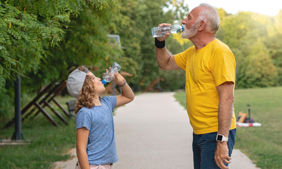 boy and grandfather drink water to avoid dehydration symptoms