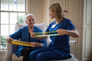 A therapist and a female patient practice stretching bands