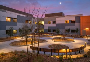 Outdoor courtyard at dawn with cotton candy skies and a lit pathway
