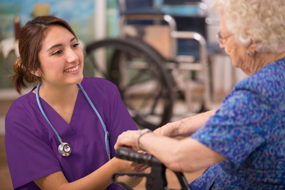 Caring nurse talks with her elderly patient.