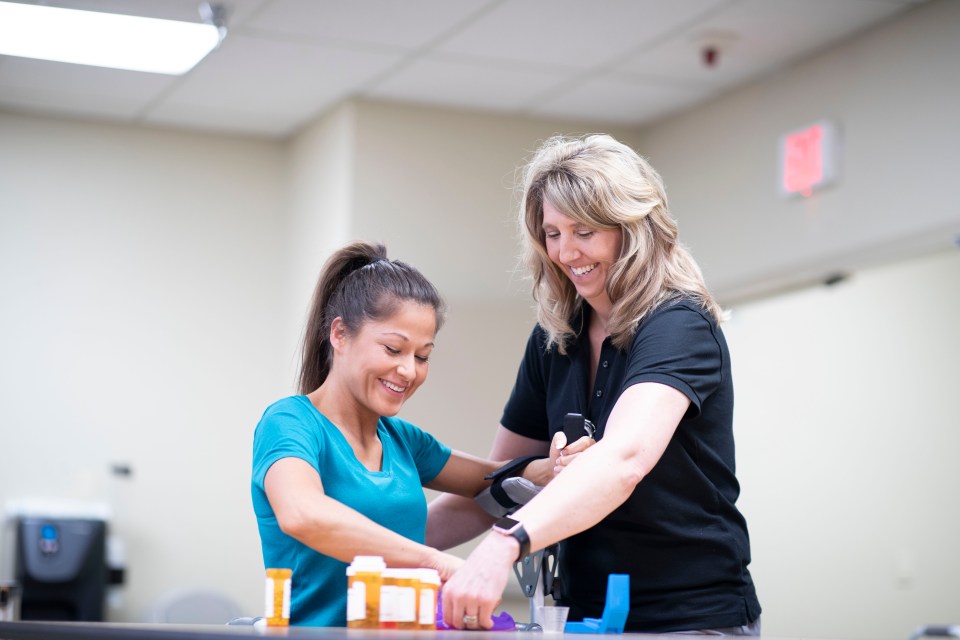 An occupational therapist helps a patient sort medication as part of a therapy session