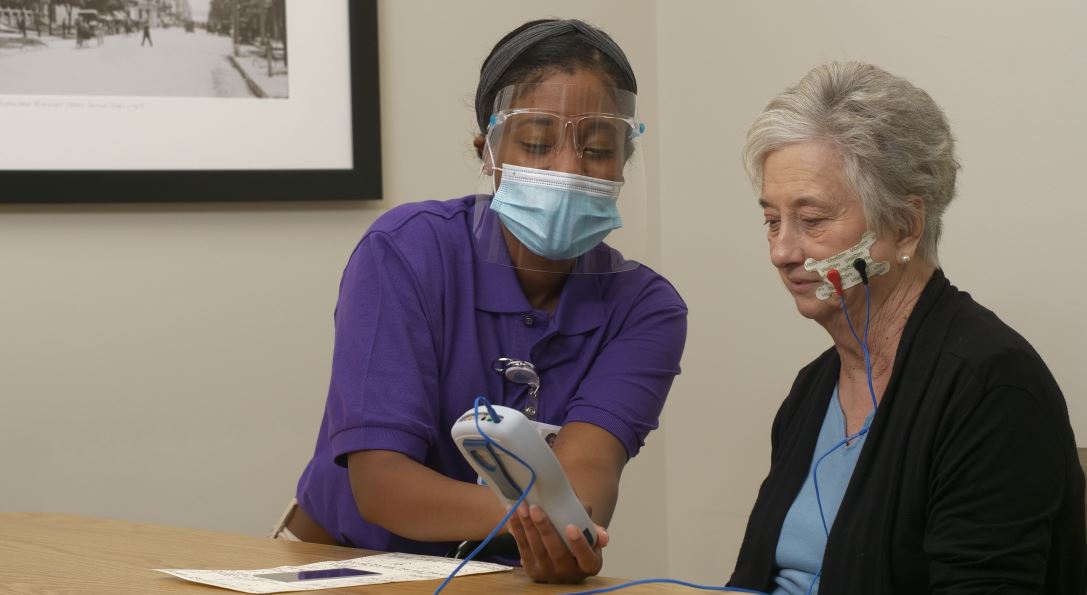 Speech therapist working with patient using stimulator technology