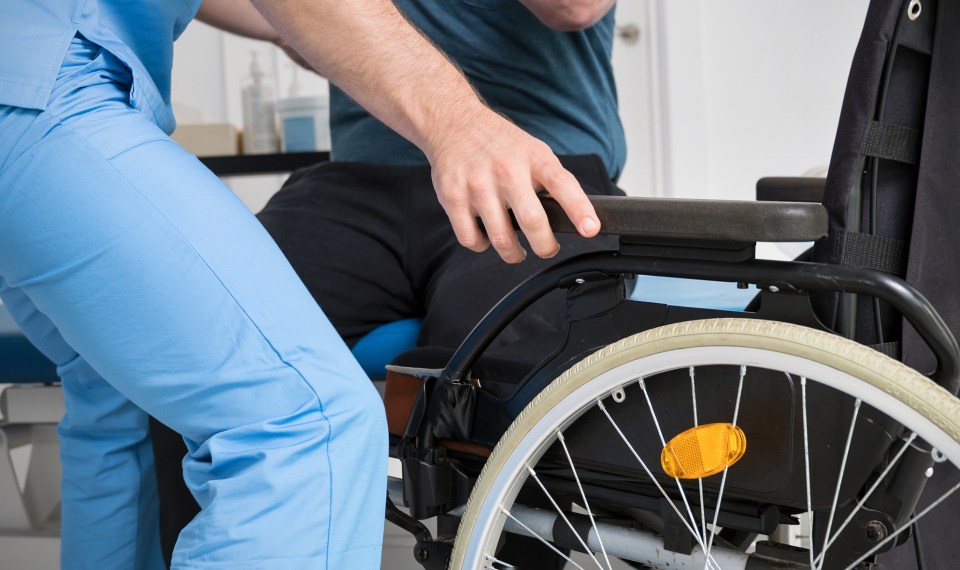 therapist helping patient with wheelchair positioning